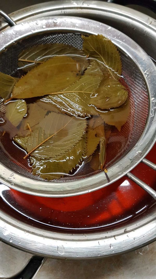 Blätter der Vin de cerises im Seiher