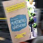 Buchcover vor Gartenplastik-Hintergrund